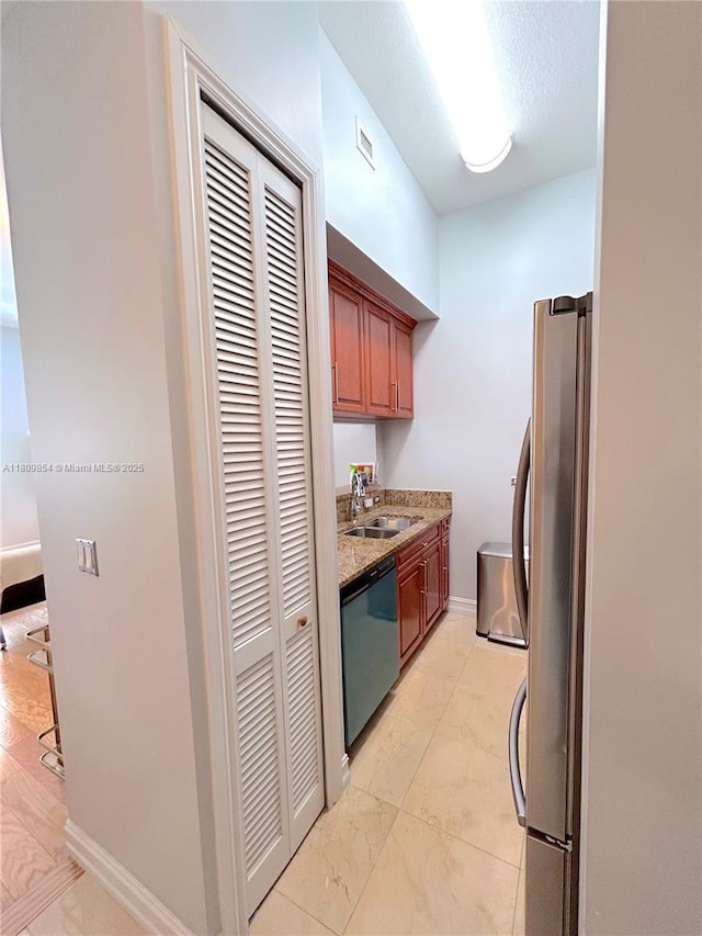 1805 Ponce De Leon Blvd Unit 626, Coral Gables, FL 33134 - kitchen featuring stainless steel appliances, light stone counters, light marble finish floors, and brown cabinetry