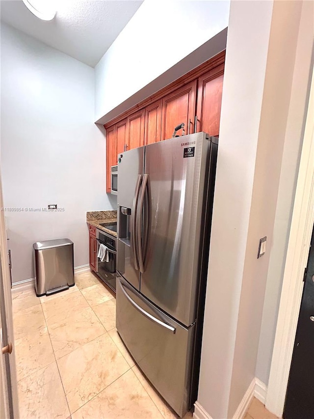 1805 Ponce De Leon Blvd Unit 626, Coral Gables, FL 33134 - kitchen featuring black appliances, baseboards, brown cabinetry, and light tile patterned floors