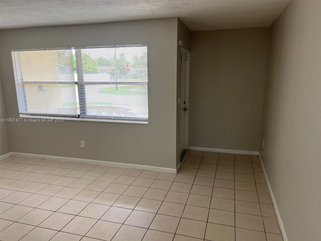 2391 NW 63rd Ter, Sunrise, FL 33313 - unfurnished room with light tile patterned flooring, a textured ceiling, and baseboards