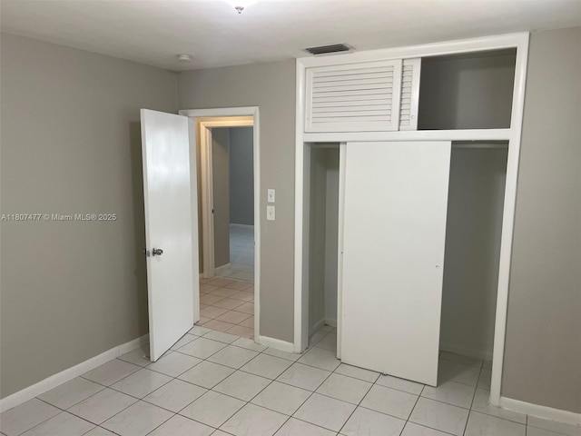 2391 NW 63rd Ter, Sunrise, FL 33313 - unfurnished bedroom with a closet, light tile patterned floors, and baseboards