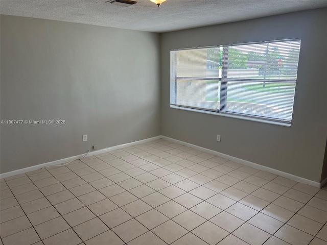 2391 NW 63rd Ter, Sunrise, FL 33313 - empty room featuring a textured ceiling, healthy amount of natural light, light tile patterned flooring, and baseboards