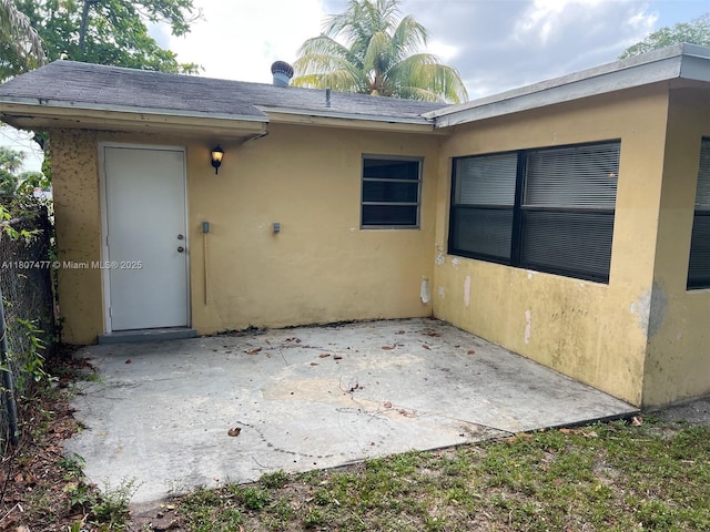 2391 NW 63rd Ter, Sunrise, FL 33313 - rear view of house featuring a patio area, stucco siding, and roof with shingles