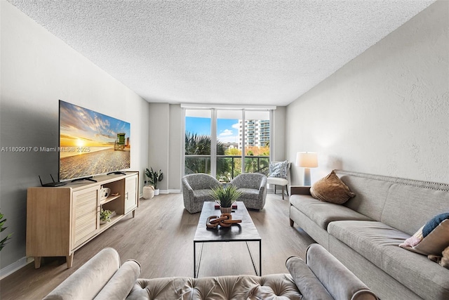 19380 Collins Ave Unit 317, Sunny Isles Beach, FL 33160 - living room featuring a textured ceiling, wood finished floors, baseboards, and a wall of windows