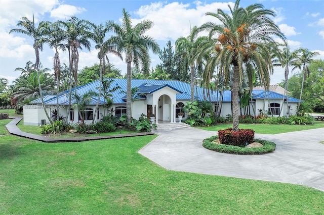 15960 SW 250th St, Homestead, FL 33031 - ranch-style house with curved driveway, a front yard, stucco siding, and metal roof