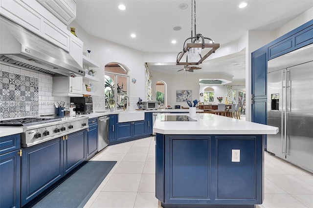 15960 SW 250th St, Homestead, FL 33031 - kitchen featuring blue cabinets, stainless steel appliances, under cabinet range hood, plenty of natural light, and recessed lighting