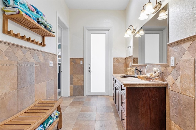 15960 SW 250th St, Homestead, FL 33031 - bathroom featuring tile walls, double vanity, a wainscoted wall, and a chandelier