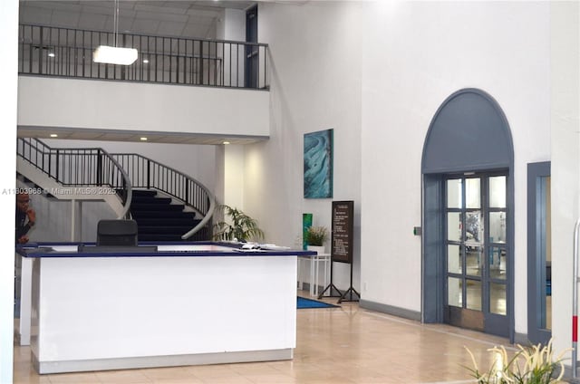 13499 Biscayne Blvd Unit 702, North Miami, FL 33181 - living area with a high ceiling, arched walkways, stairs, and baseboards