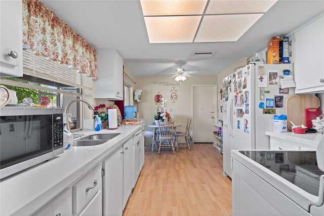 1090 NW 66th Ter, Margate, FL 33063 - kitchen with a sink, stainless steel microwave, light wood finished floors, white cabinetry, and electric stove