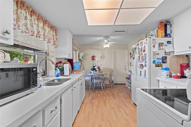 1090 NW 66th Ter, Margate, FL 33063 - kitchen with a sink, stainless steel microwave, light wood finished floors, white cabinetry, and electric stove