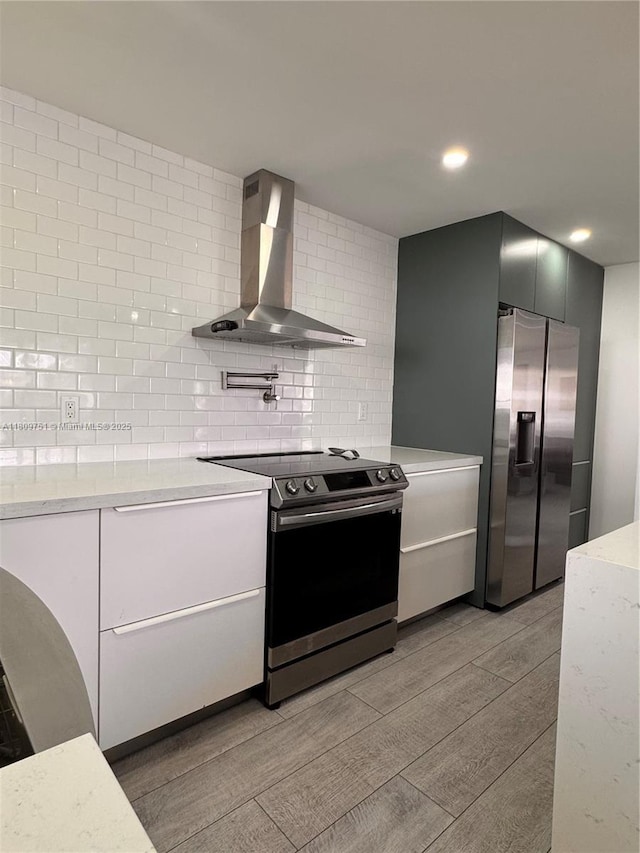 501 SW 18th St, Pompano Beach, FL 33060 - kitchen with wall chimney exhaust hood, appliances with stainless steel finishes, tasteful backsplash, light wood finished floors, and recessed lighting