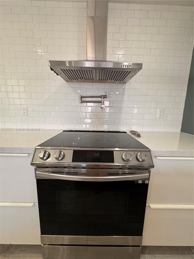 501 SW 18th St, Pompano Beach, FL 33060 - kitchen featuring electric stove, wall chimney exhaust hood, backsplash, and light stone counters