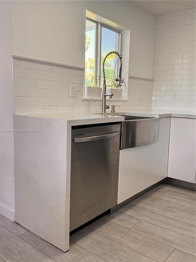 501 SW 18th St, Pompano Beach, FL 33060 - kitchen with stainless steel dishwasher, light countertops, decorative backsplash, white cabinets, and a sink