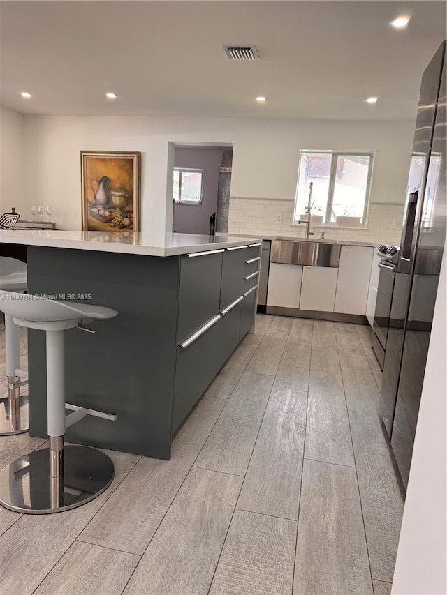 501 SW 18th St, Pompano Beach, FL 33060 - kitchen featuring modern cabinets, light countertops, light wood-type flooring, a sink, and recessed lighting