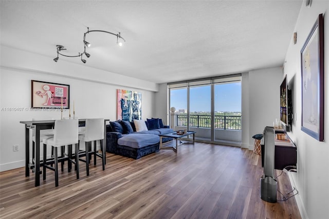 3232 SW 22nd Ter Unit 1106, Miami, FL 33145 - living room with wood finished floors, baseboards, a textured ceiling, and bar