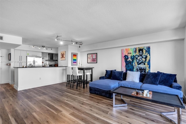 3232 SW 22nd Ter Unit 1106, Miami, FL 33145 - living room featuring a textured ceiling, wood finished floors, rail lighting, and baseboards