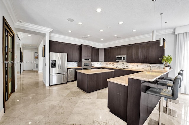 11356 Canyon Maple Blvd, Davie, FL 33330 - kitchen featuring stainless steel appliances, dark brown cabinets, crown molding, a center island, and tasteful backsplash