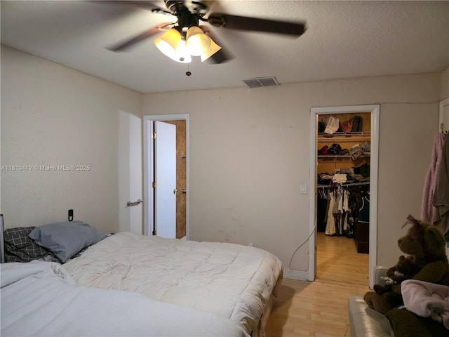 22374 SW 57th Cir, Boca Raton, FL 33428 - bedroom with a walk in closet, a closet, light wood-type flooring, and ceiling fan