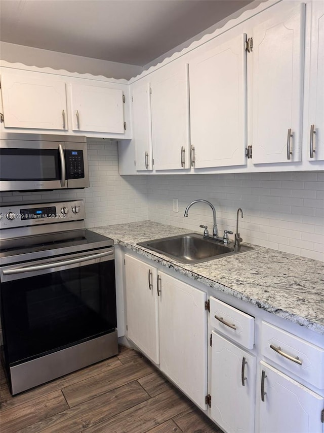 218 Windsor J Unit 218, West Palm Beach, FL 33417 - kitchen with appliances with stainless steel finishes, a sink, white cabinetry, and decorative backsplash