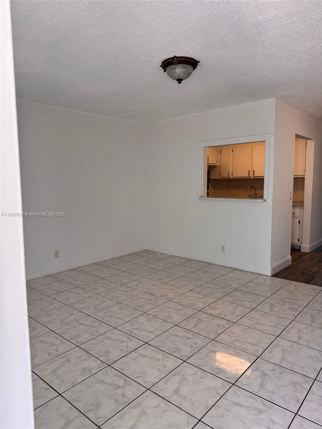 218 Windsor J Unit 218, West Palm Beach, FL 33417 - spare room featuring a textured ceiling and baseboards