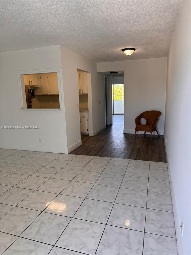 218 Windsor J Unit 218, West Palm Beach, FL 33417 - spare room featuring a textured ceiling, light wood finished floors, and baseboards