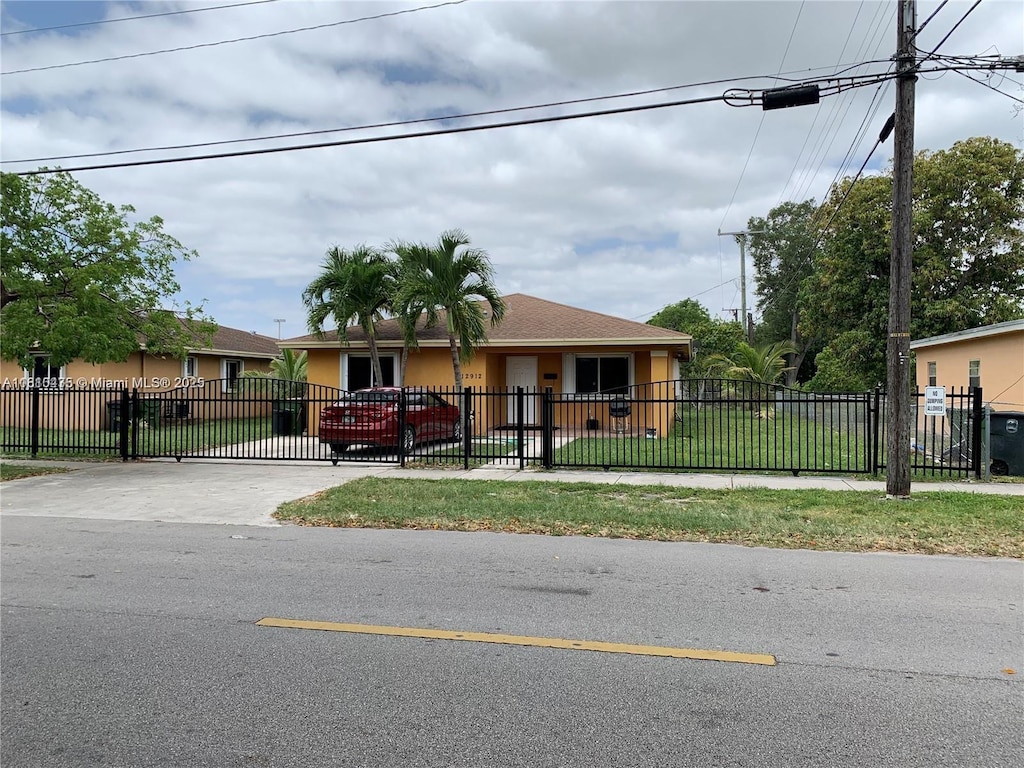 12912 NE 7th Ave, North Miami, FL 33161 - view of front of property featuring stucco siding, a fenced front yard, concrete driveway, and a gate