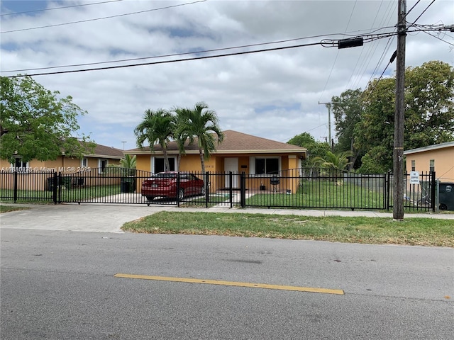 12912 NE 7th Ave, North Miami, FL 33161 - view of front of property featuring stucco siding, a fenced front yard, concrete driveway, and a gate