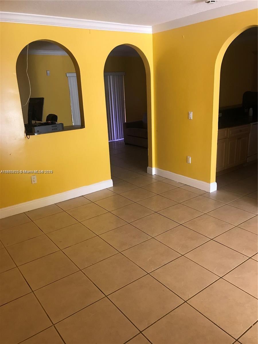 12912 NE 7th Ave, North Miami, FL 33161 - tiled empty room featuring crown molding