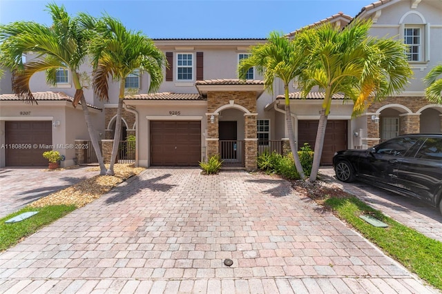 9285 SW 220th Ter, Cutler Bay, FL 33190 - view of front of house with stucco siding, decorative driveway, a tiled roof, stone siding, and a gate