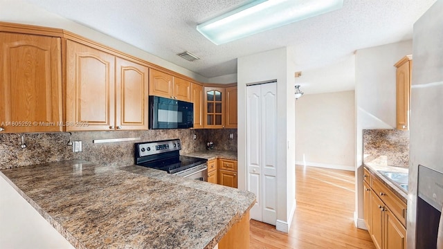 15141 SW 46th St, Miramar, FL 33027 - kitchen featuring black microwave, electric stove, light wood-style flooring, tasteful backsplash, and glass insert cabinets