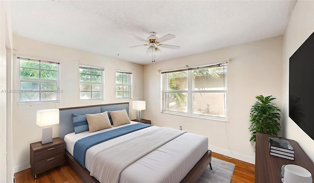 15141 SW 46th St, Miramar, FL 33027 - bedroom with multiple windows, wood finished floors, a textured ceiling, and a ceiling fan