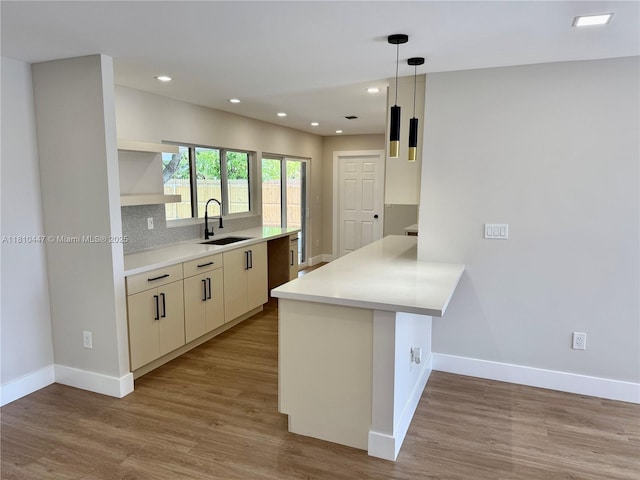 5506 SW 134th Pl, Miami, FL 33175 - kitchen with a sink, open shelves, a peninsula, baseboards, and wood finished floors