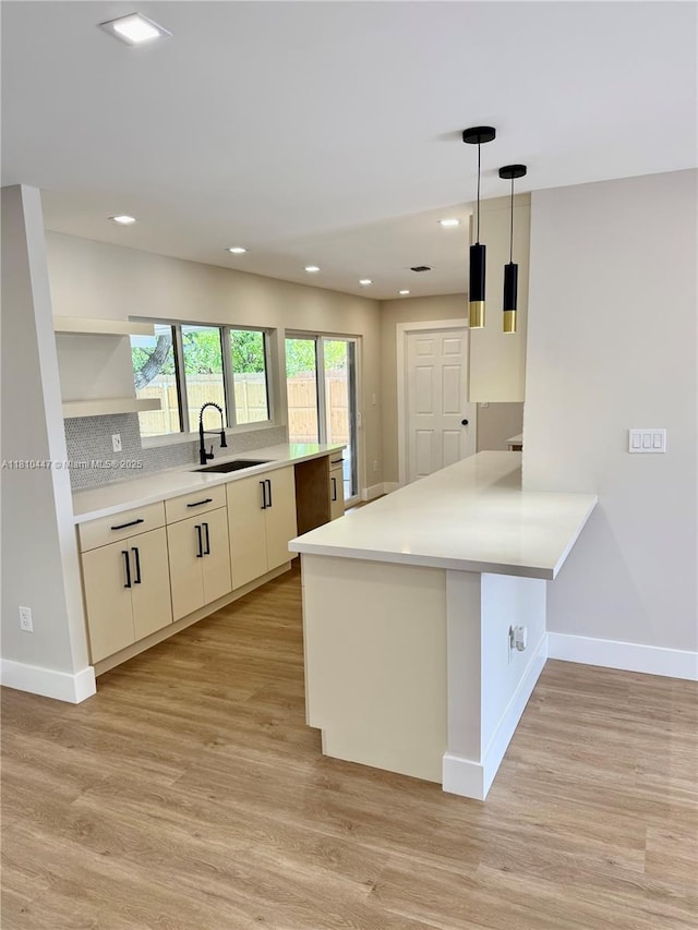 5506 SW 134th Pl, Miami, FL 33175 - kitchen with a sink, a peninsula, baseboards, light wood-style flooring, and recessed lighting