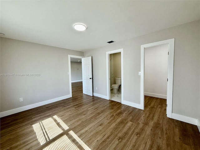 5506 SW 134th Pl, Miami, FL 33175 - unfurnished bedroom with baseboards, wood finished floors, a walk in closet, and ensuite bathroom