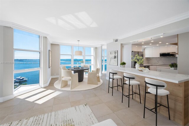 1901 Brickell Ave Unit B1114, Miami, FL 33129 - kitchen featuring a kitchen breakfast bar, crown molding, white cabinetry, stainless steel appliances, and modern cabinets