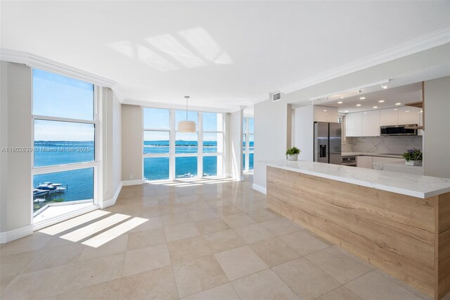 1901 Brickell Ave Unit B1114, Miami, FL 33129 - unfurnished living room featuring a water view, ornamental molding, expansive windows, and light tile patterned flooring