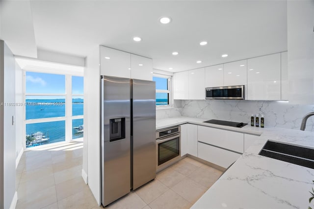 1901 Brickell Ave Unit B1114, Miami, FL 33129 - kitchen with appliances with stainless steel finishes, modern cabinets, a sink, white cabinetry, and tasteful backsplash