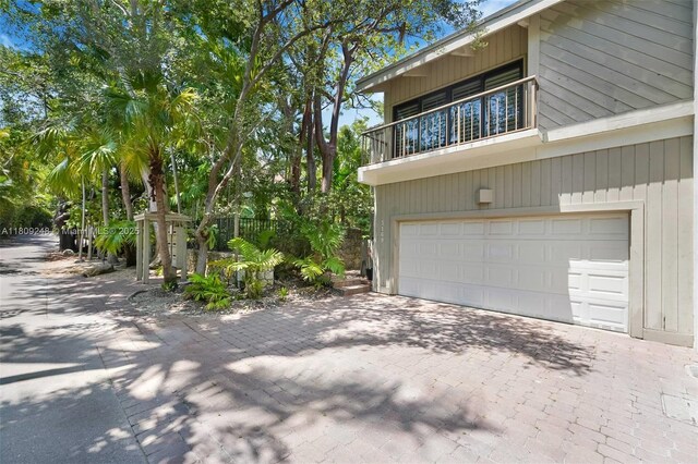 3169 Via Abitare Way Unit 6, Miami, FL 33133 - view of side of home with decorative driveway, a balcony, and a garage