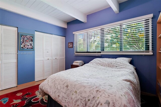 3169 Via Abitare Way Unit 6, Miami, FL 33133 - bedroom with beamed ceiling, two closets, and wood finished floors