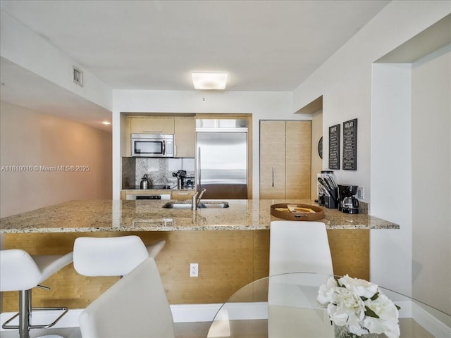 1830 S Ocean Dr Unit 5009, Hallandale Beach, FL 33009 - kitchen with stainless steel appliances, a sink, a peninsula, and light stone countertops