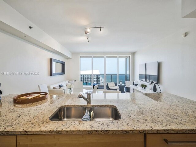 1830 S Ocean Dr Unit 5009, Hallandale Beach, FL 33009 - kitchen with a sink, open floor plan, light stone counters, and rail lighting