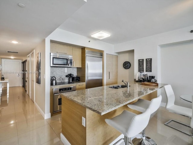 1830 S Ocean Dr Unit 5009, Hallandale Beach, FL 33009 - kitchen with appliances with stainless steel finishes, a breakfast bar area, a peninsula, tasteful backsplash, and a sink