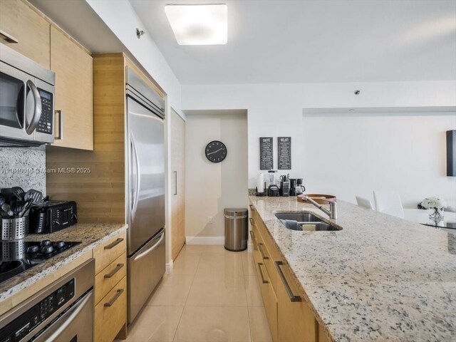 1830 S Ocean Dr Unit 5009, Hallandale Beach, FL 33009 - kitchen featuring appliances with stainless steel finishes, a sink, tasteful backsplash, light tile patterned flooring, and light stone countertops