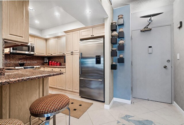 1985 S Ocean Dr Unit 17D, Hallandale Beach, FL 33009 - kitchen with appliances with stainless steel finishes, backsplash, light brown cabinets, light tile patterned flooring, and recessed lighting