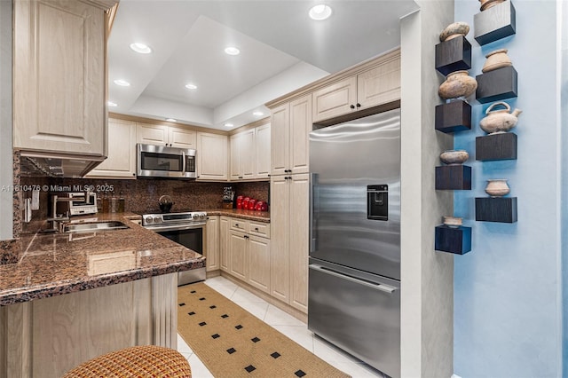 1985 S Ocean Dr Unit 17D, Hallandale Beach, FL 33009 - kitchen featuring appliances with stainless steel finishes, tasteful backsplash, light tile patterned flooring, dark stone counters, and recessed lighting