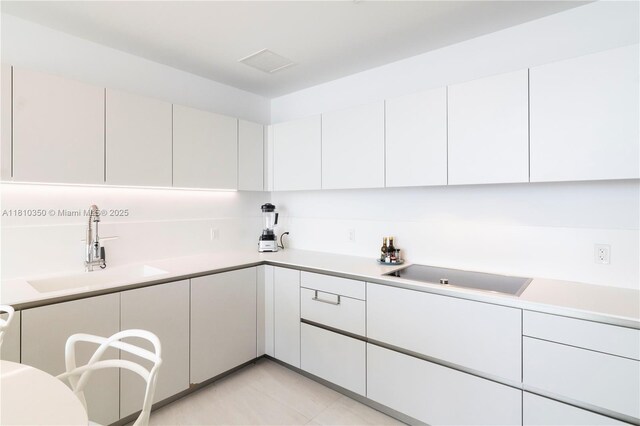 16901 Collins Ave Unit 2504, Sunny Isles Beach, FL 33160 - kitchen featuring a sink, light countertops, white cabinetry, and light tile patterned floors