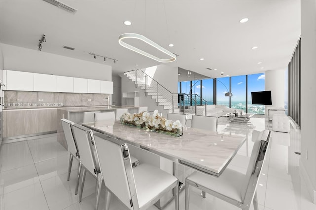3131 NE 7th Ave Unit Uph5303, Miami, FL 33137 - dining space featuring a wall of windows, stairs, recessed lighting, and light tile patterned floors