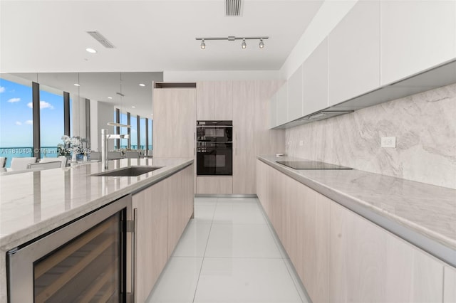 3131 NE 7th Ave Unit Uph5303, Miami, FL 33137 - kitchen with modern cabinets, beverage cooler, a sink, light stone counters, and black appliances