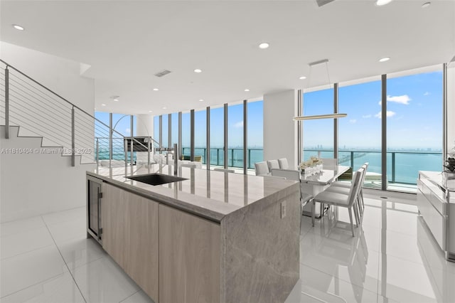 3131 NE 7th Ave Unit Uph5303, Miami, FL 33137 - kitchen with modern cabinets, a sink, a water view, floor to ceiling windows, and an island with sink
