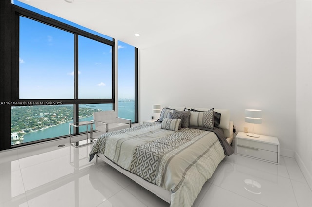 3131 NE 7th Ave Unit Uph5303, Miami, FL 33137 - tiled bedroom featuring a wall of windows, a water view, and baseboards