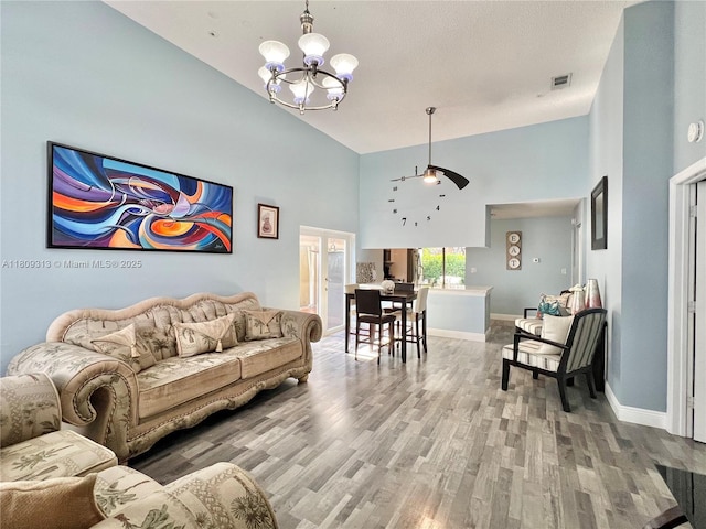 15333 SW 40th Ter, Miami, FL 33185 - living area with a chandelier, wood finished floors, baseboards, a high ceiling, and a ceiling fan